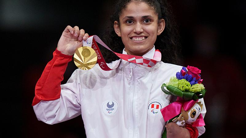Peruvian taekwondin Angelica Espinoza smiles on the podium while holding the gold medal