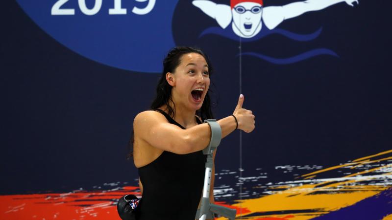 a female Para swimmer gives the thumbs up 