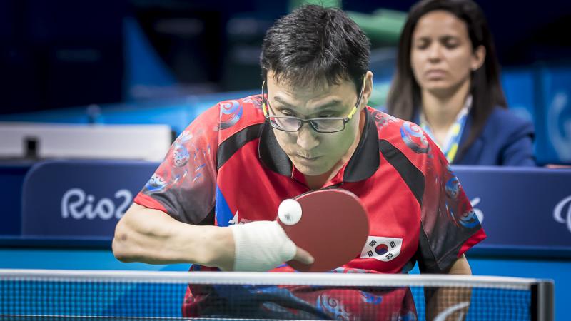Korean male in wheelchair hits return shot in table tennis