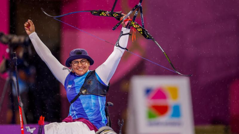 Female archer raises arms in triumph