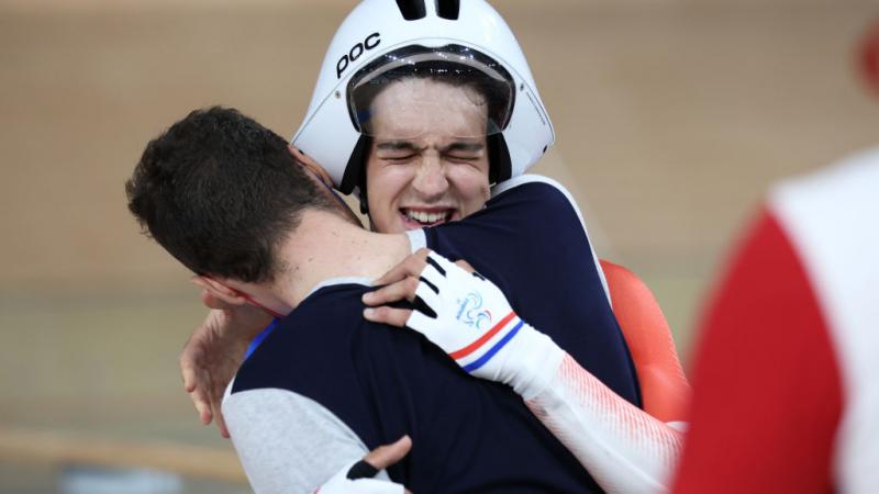 Para cyclist Alexandre Leaute hugs a member of his team in celebration