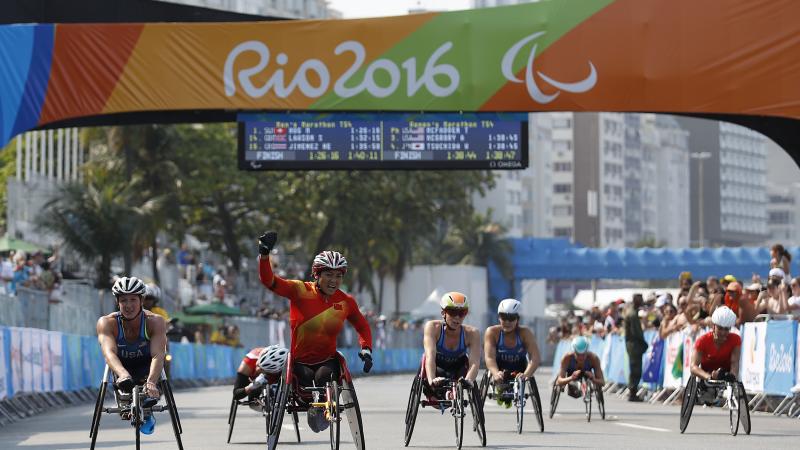 Lihong Zou of China celebrates as she win Gold Medal ahead of Tatyana McFadden USA in Silver Medal position in the Women's T54 Marathon at the Rio 2016 Paralympic Games.