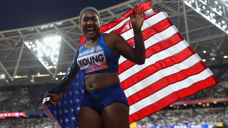 Deja Young laughs while waiving the US flag