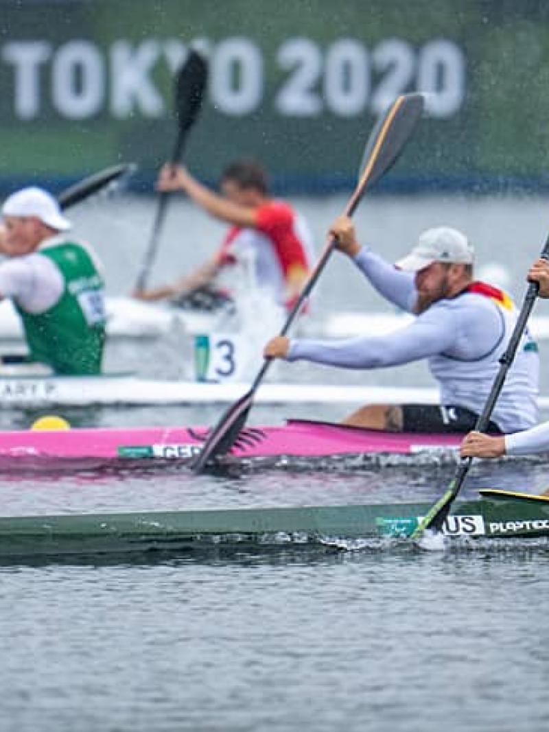 four male Para canoeists paddling in a race