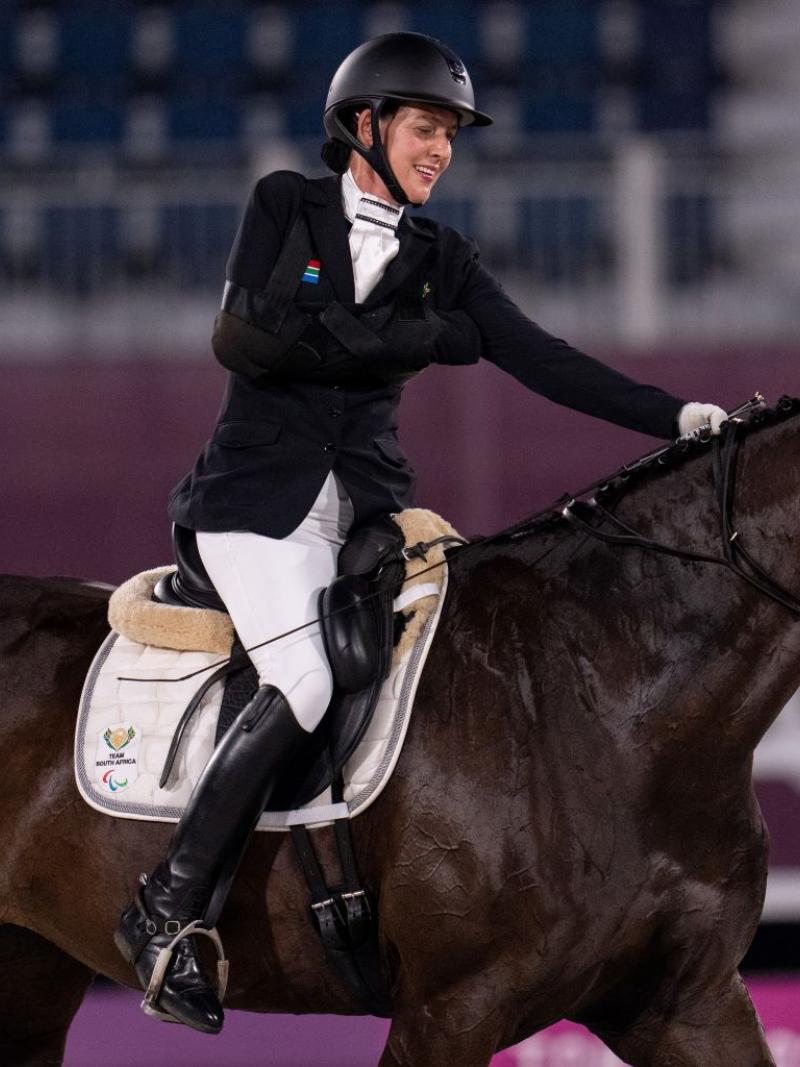 A female Para equestrian athlete rides a horse
