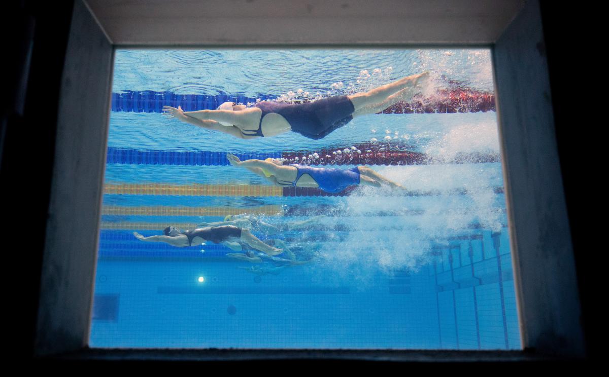 An underwater image of female Para athletes swimming backstroke