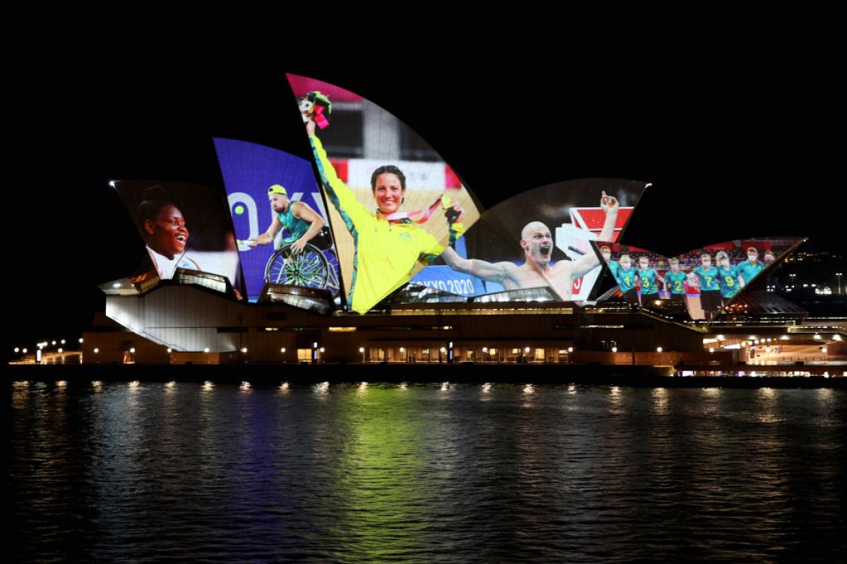 Photos of Australian Paralympians from Tokyo 2020 are projected on the Sydney Opera House at nighttime