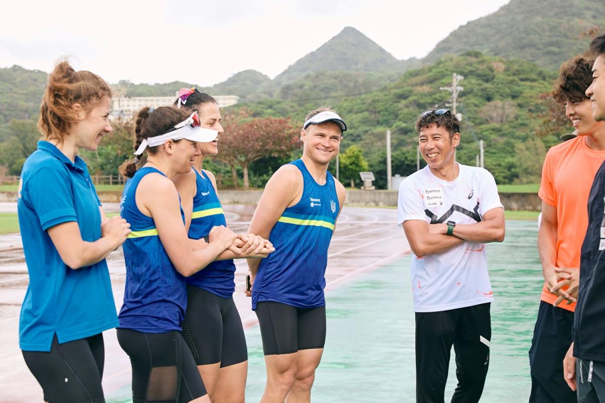 Four Para triathletes and official from Ukraine are speaking with Japanese athletes