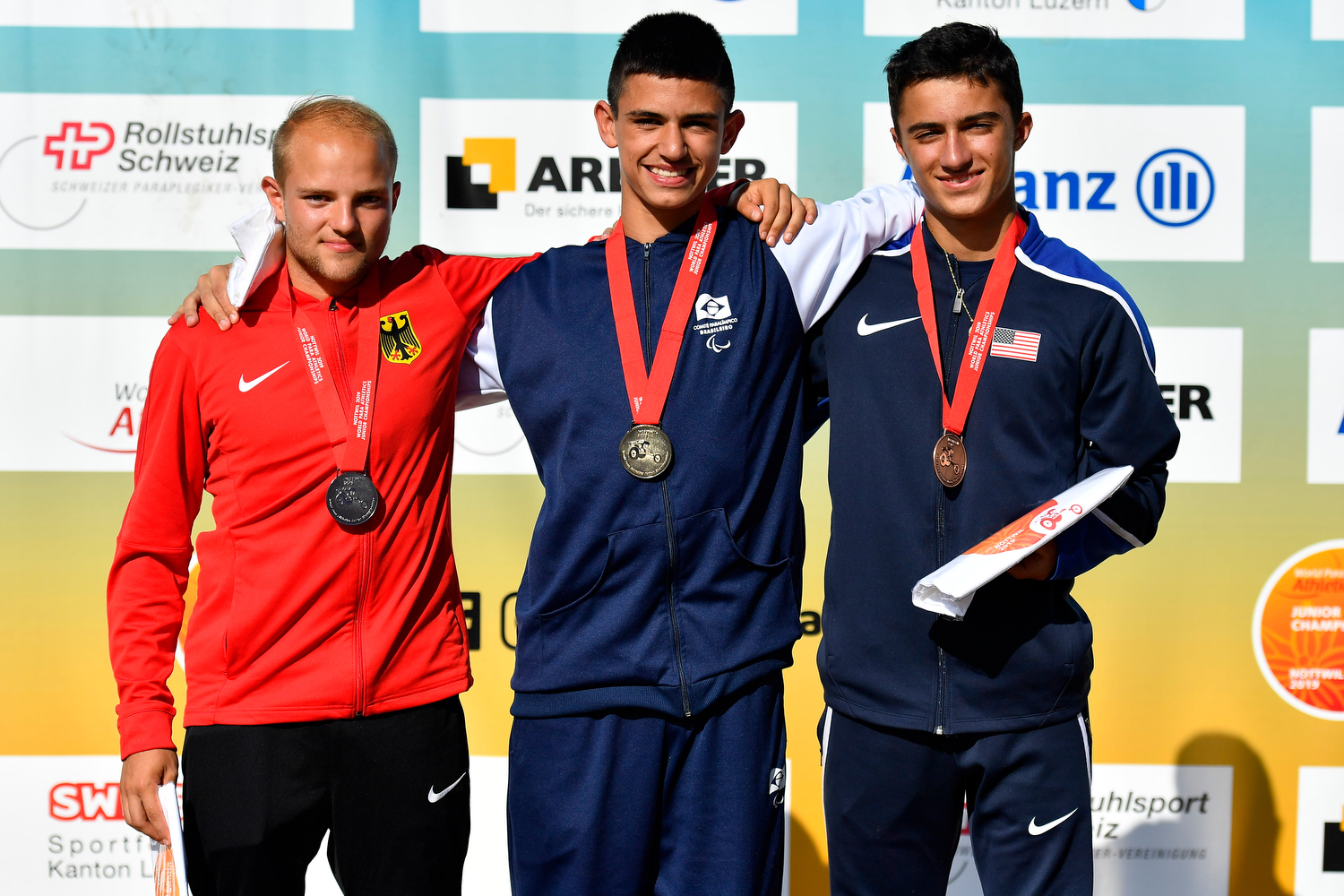 Three young men on a podium with their medals