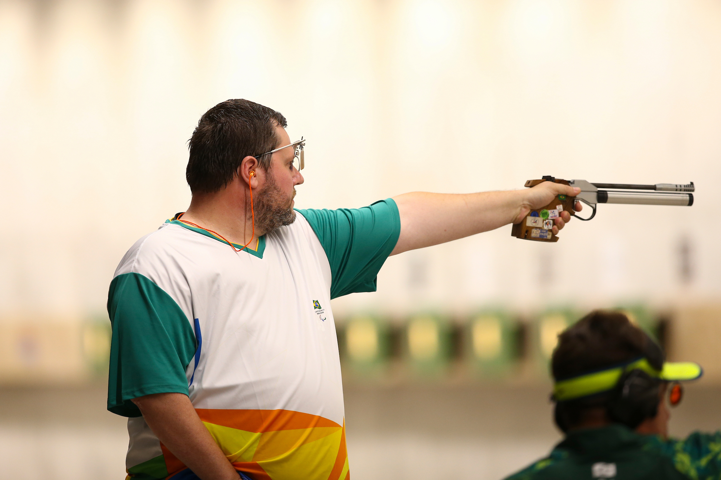 a male Para shooter points a pistol at a target