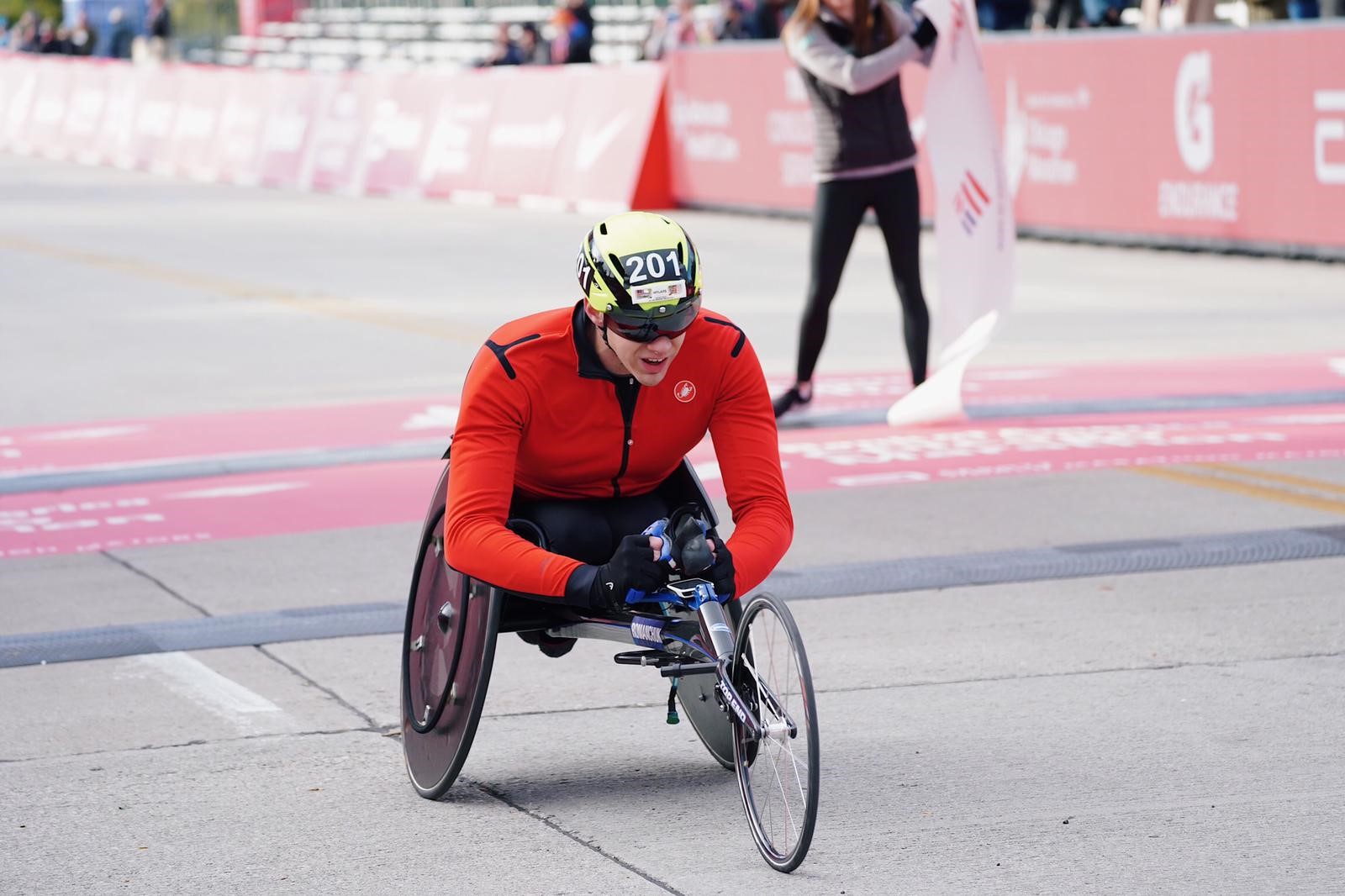 A man in a wheelchair race crossing the finish line of the Chicago Marathon