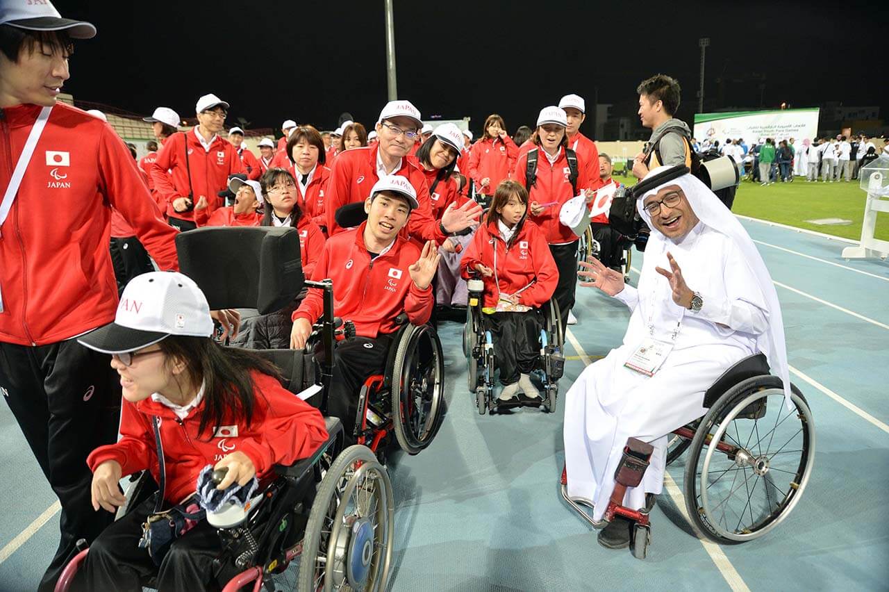 Japan delegation with man in wheelchair smiling with them