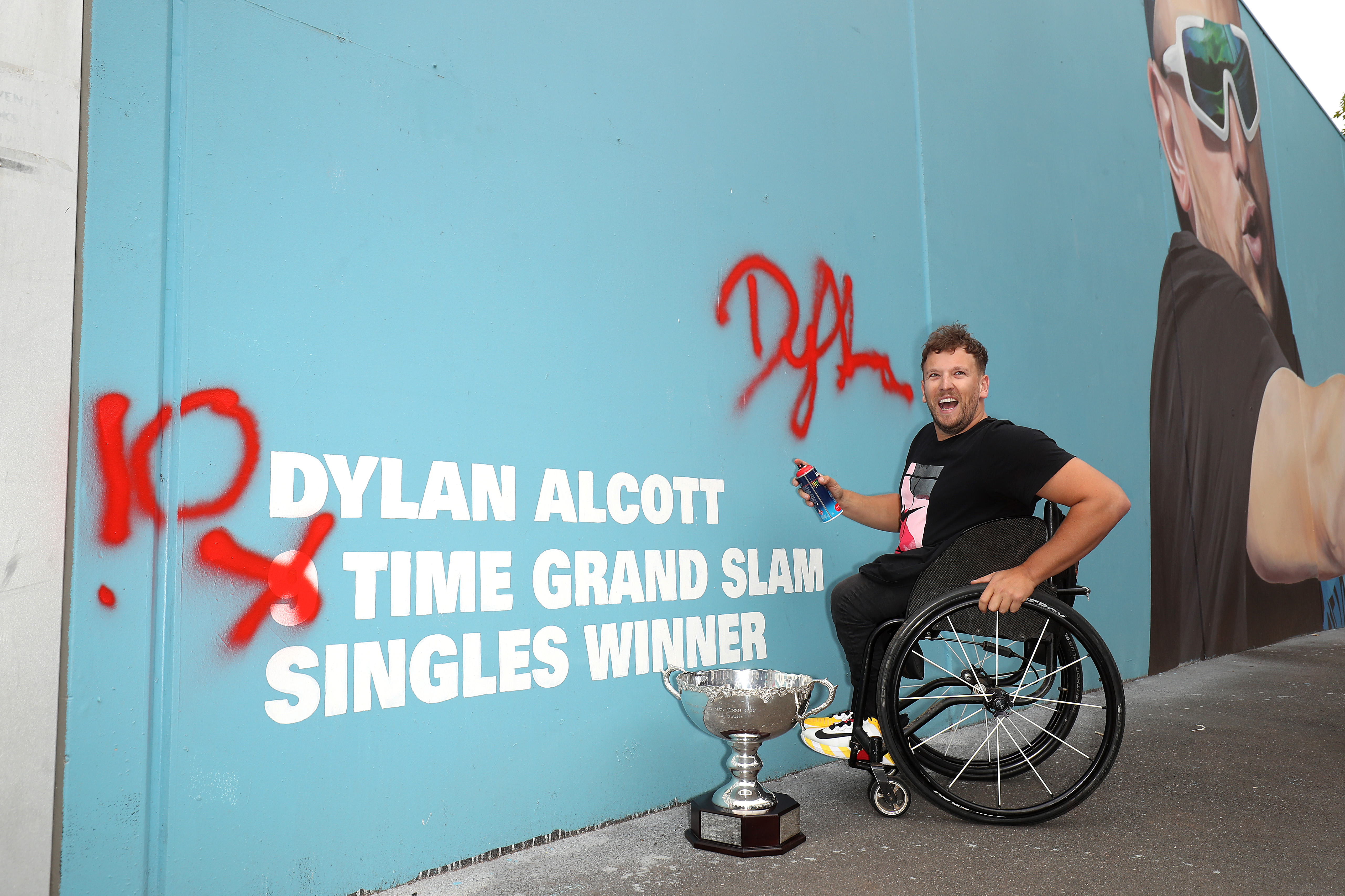 Male wheelchair tennis player next to wall art