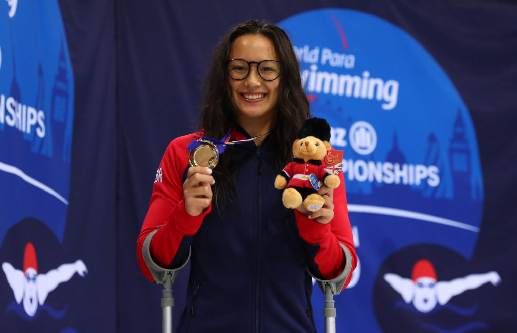 Alice Tai smiles as she holds up a bear mascot and her gold medal from the women's 100m freestyle S8 at the London 2019 World Para Swimming Championships.