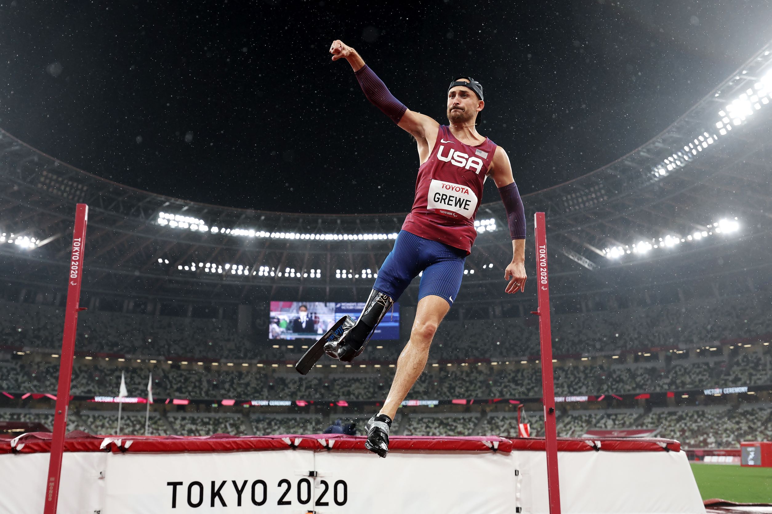 A male high jumper raises his right fist in celebration after winning his event at the Tokyo 2020 Paralympic Games.