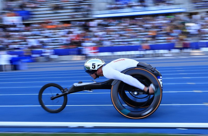 A male wheelchair racer running in front of the crowd
