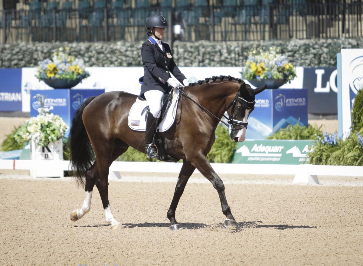 A female Para equestrian athlete rides a horse