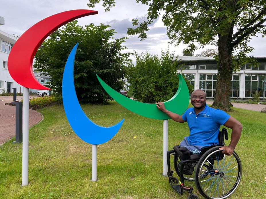 Nyasha Mharakurwa, Chef de Mission of the Refugee Paralympic Team and former wheelchair tennis player, poses for a photograph in front of the Agitos logo at the IPC headquarters