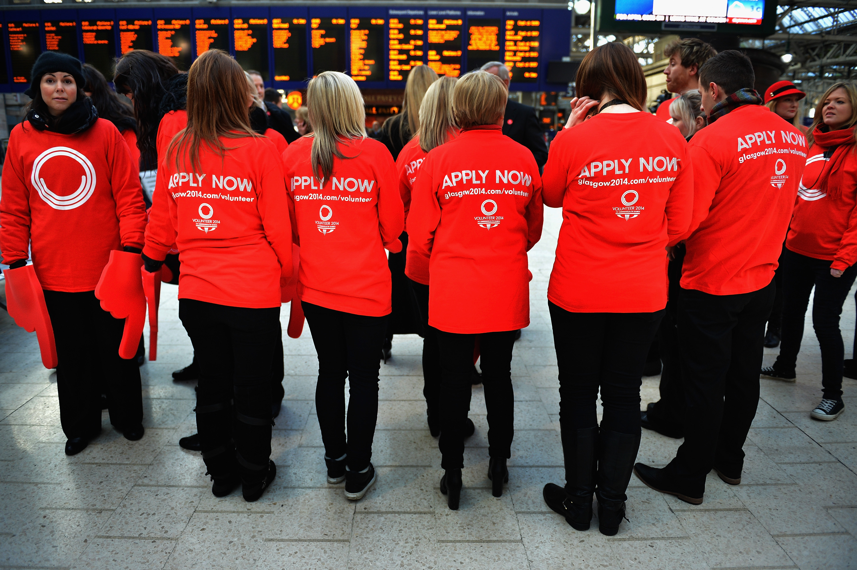 A picture of 5 persons wearing a Tshirt with "Apply Now" written on it.