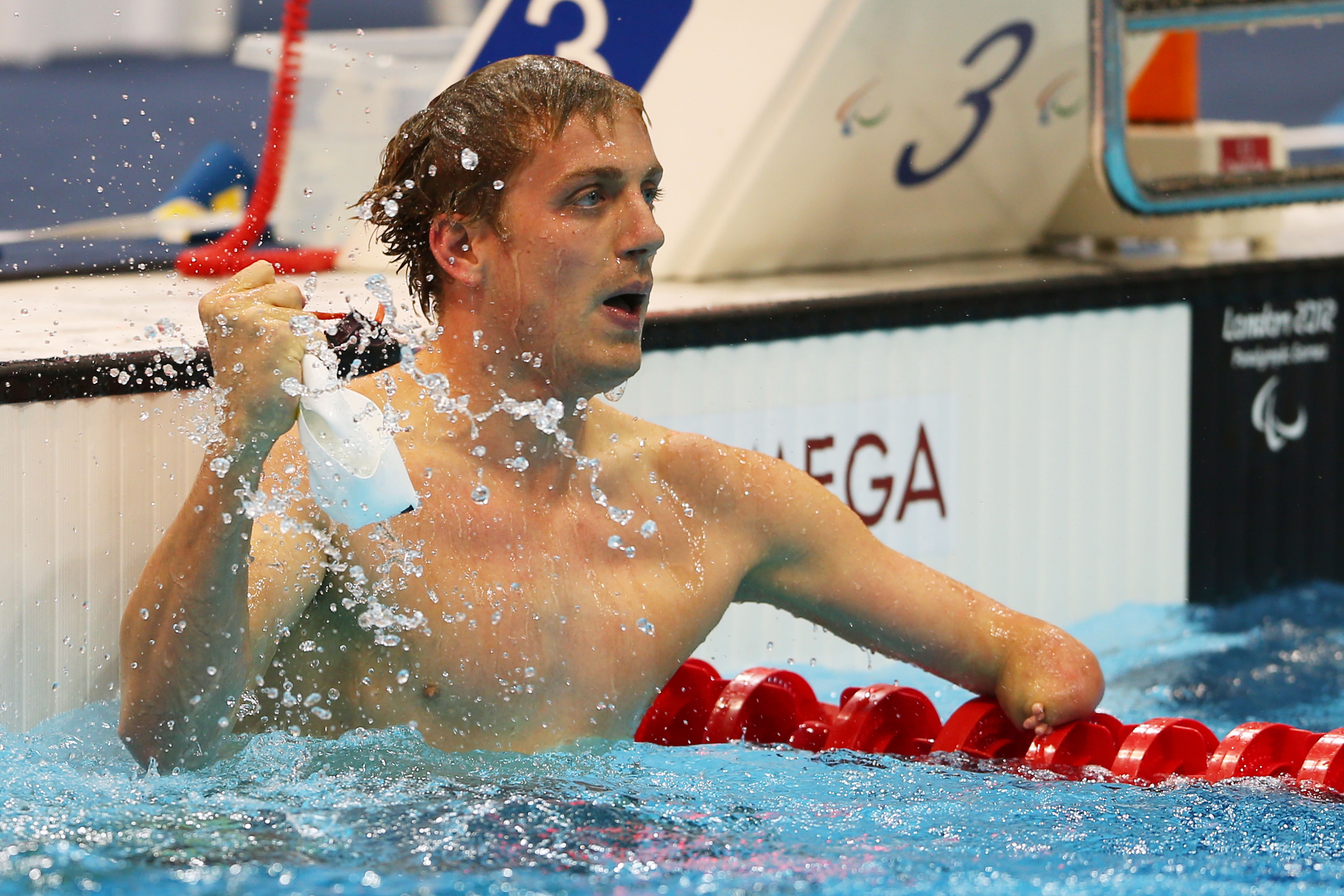 A picture of a man holding the swimming cap in his hand