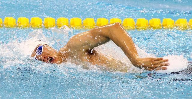 Swimmer in the water taking a breath in freestyle