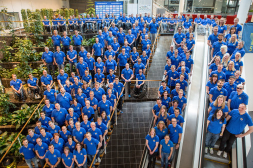 Group picture of many people in blue shirts, shot from above