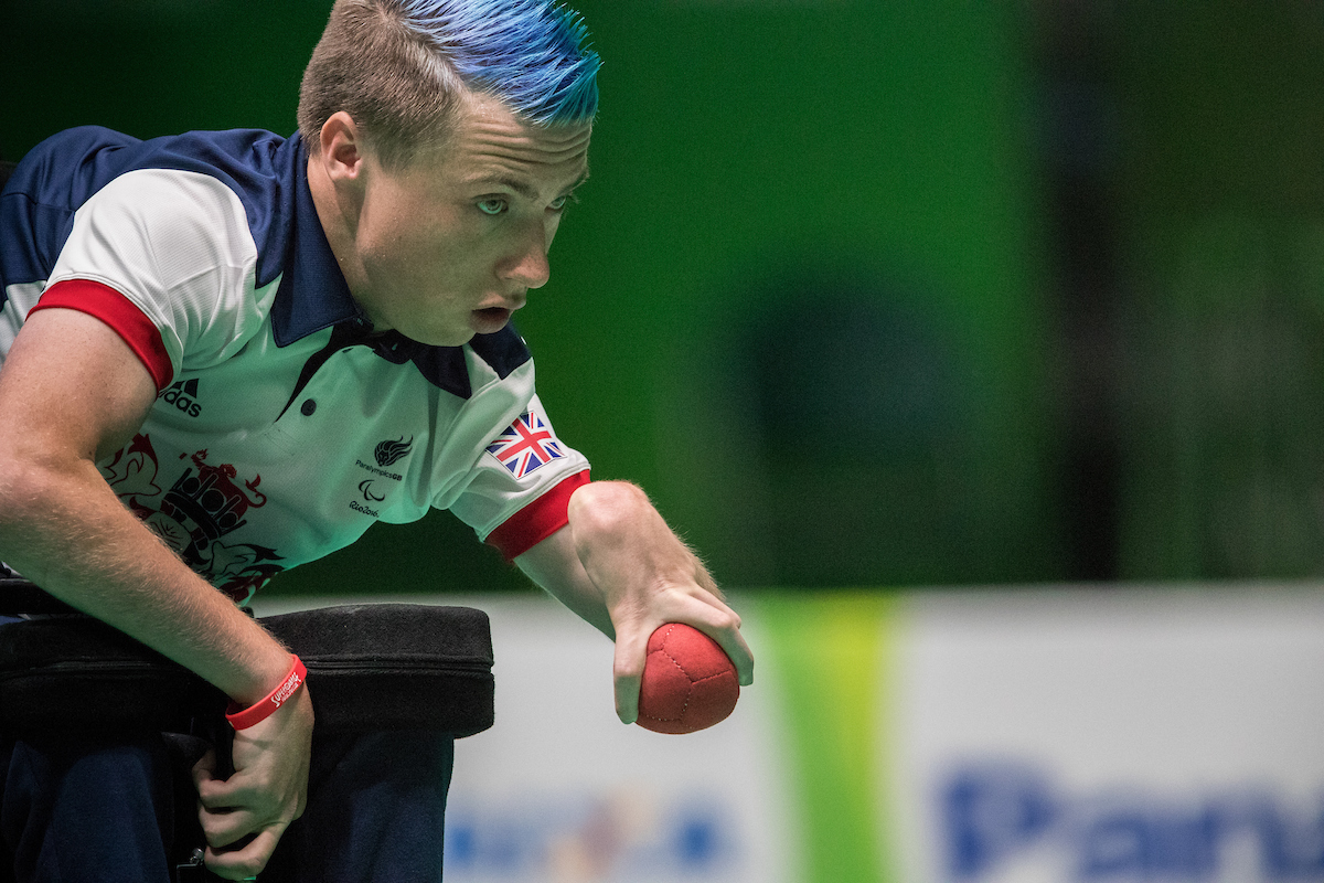 a male boccia player prepares to throw the ball