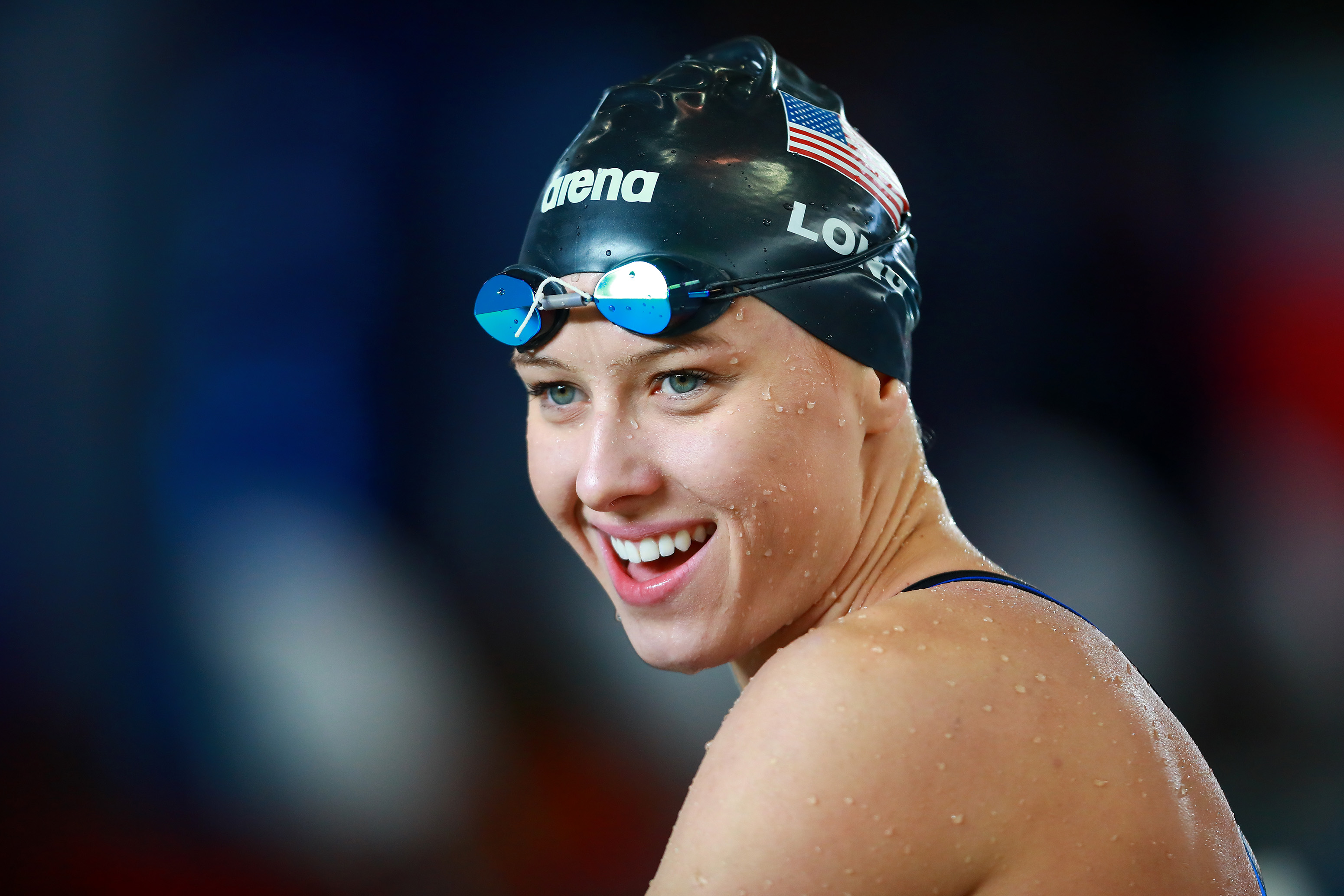 a female Para swimmer smiles after winning her race