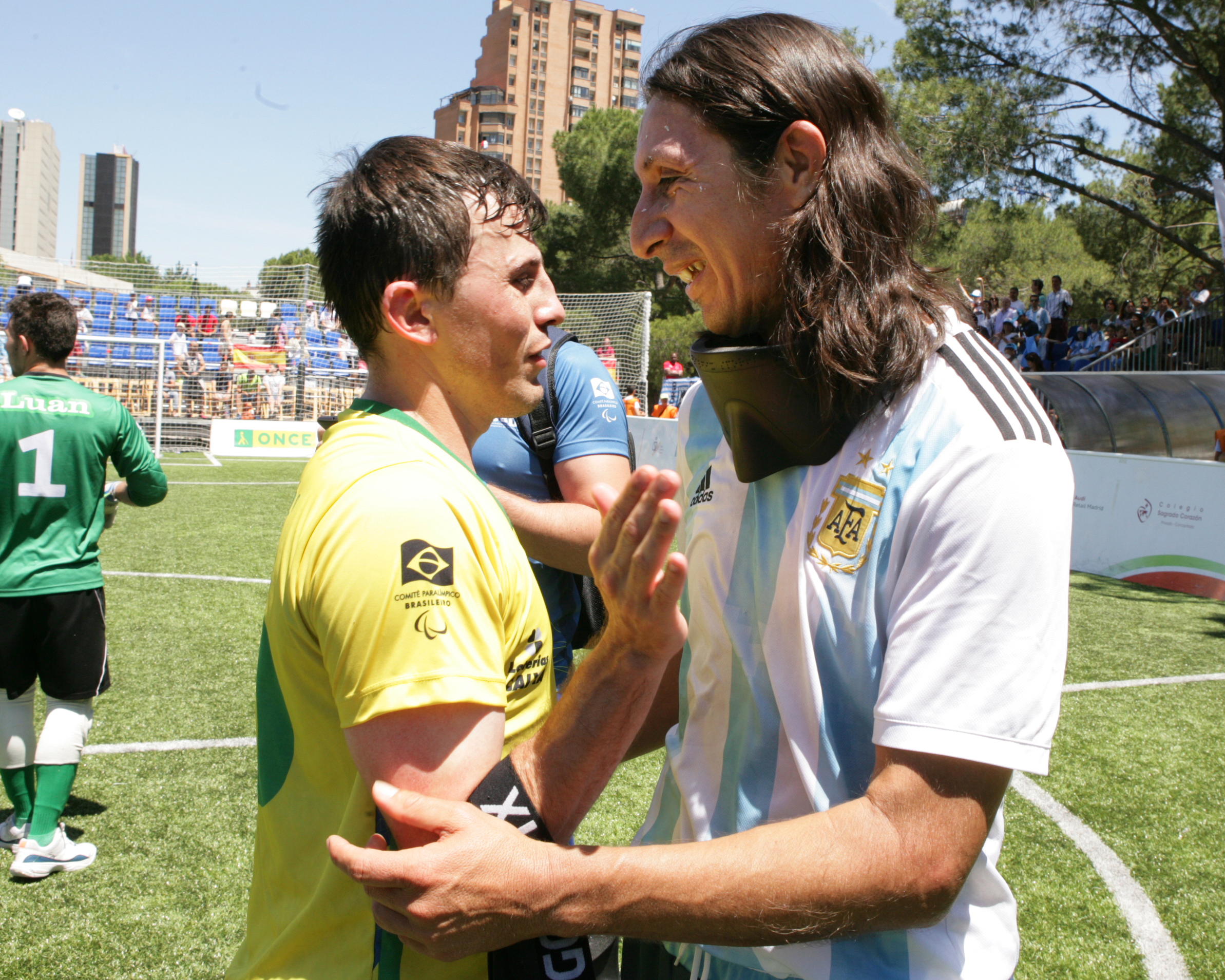 two blind footballers hugging on the pitch