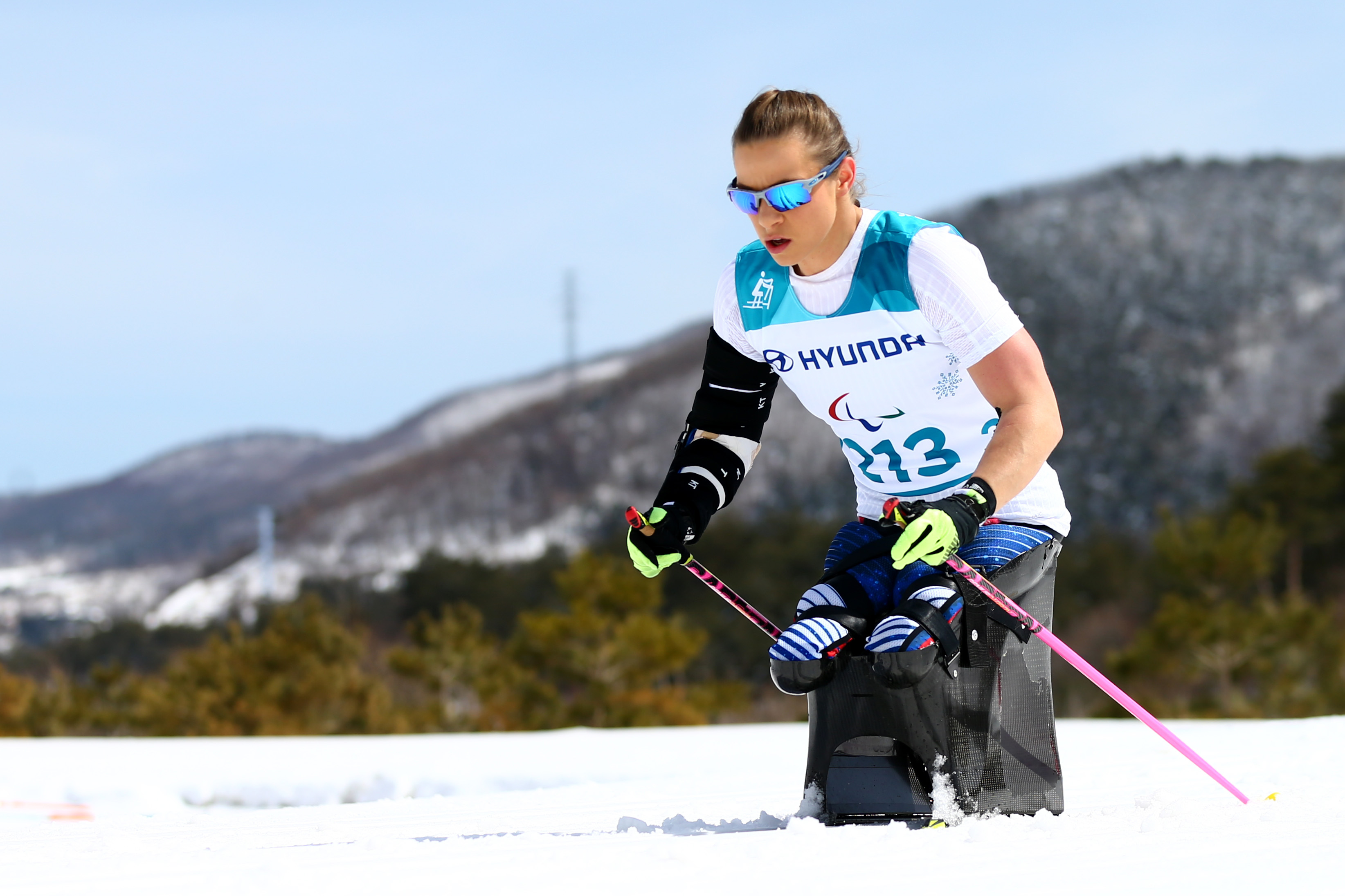 female sit skier Oksana Masters pushing through the snow
