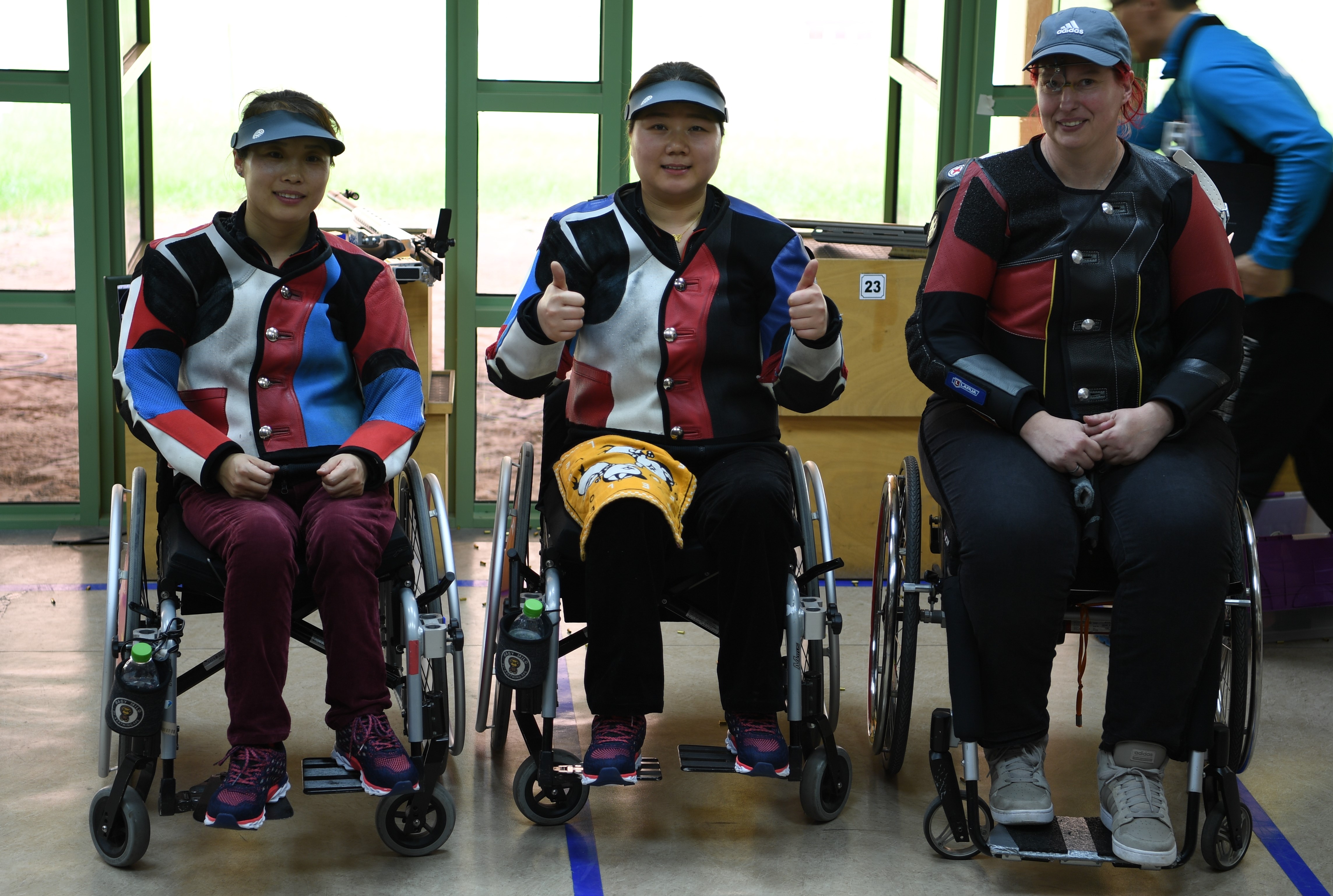 three female Para shooters with Zhang Cuiping giving a thumbs up