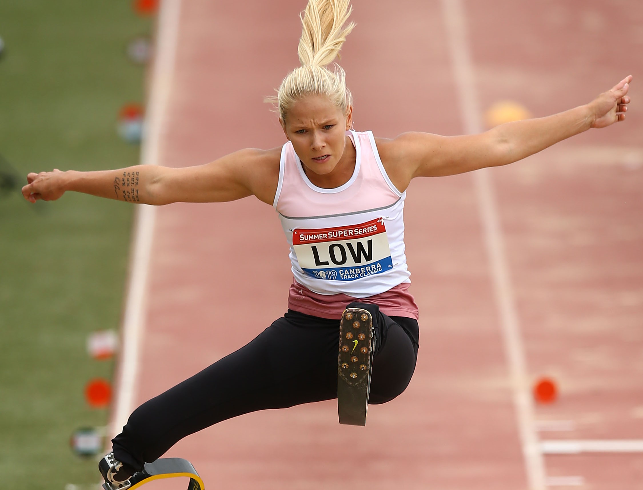 female Para athlete Vanessa Low jumps high above the long jump sandpit