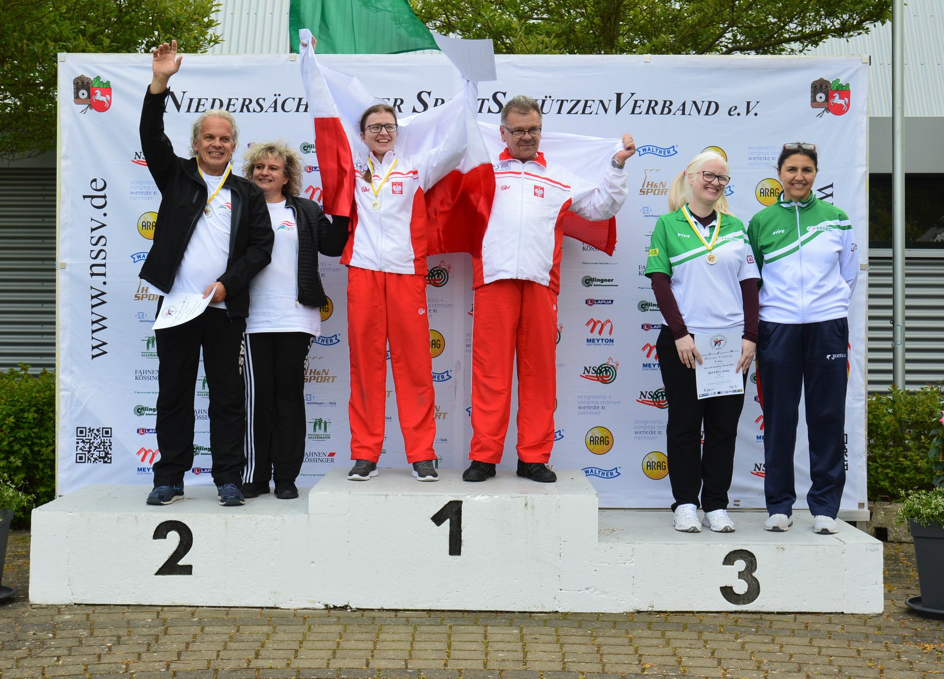 Three vision impaired shooting Para sport athletes on the podium with their guides