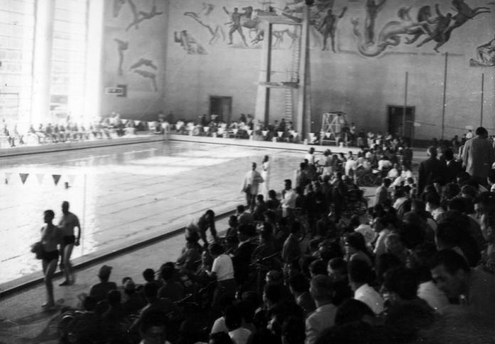 Black and white photo of packed swimming venue from Rome 1960