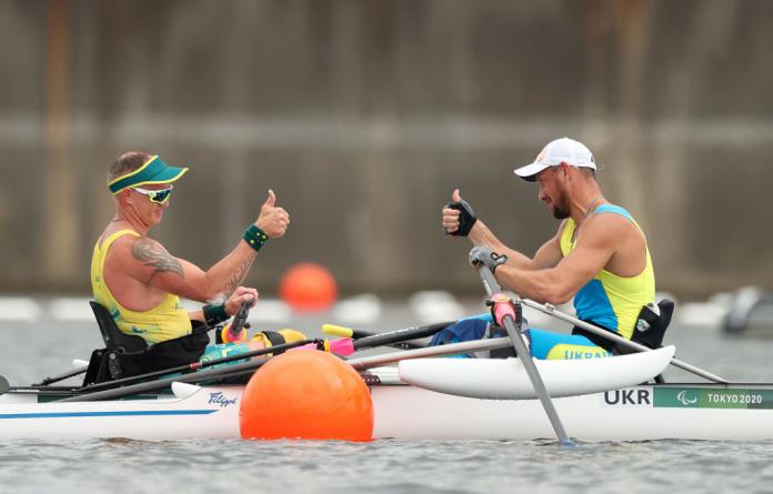 Para rower Roman Polianskyi gives the thumbs up from his boat to another rower