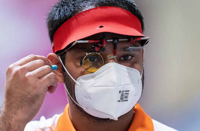 A male shooting Para sport athlete wearing a mask