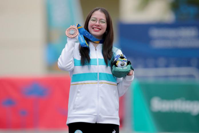 A female athlete poses for a photo after receiving a medal