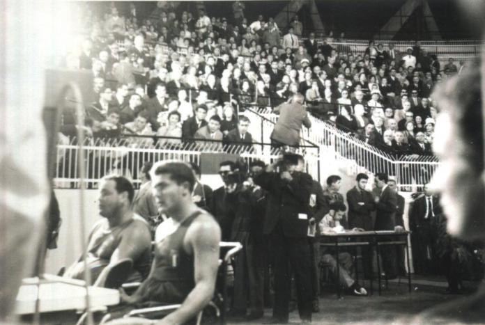 A black-and-white photo shows Para table tennis athletes are competing in front of a packed crowd