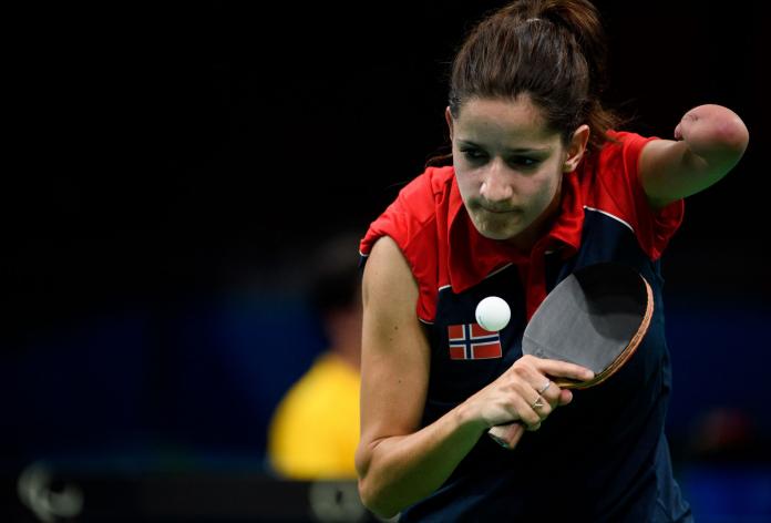 A female Para table tennis athlete is about the return the ball during competition