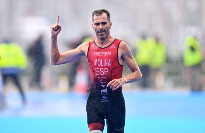A male Para triathlete points his finger during a race