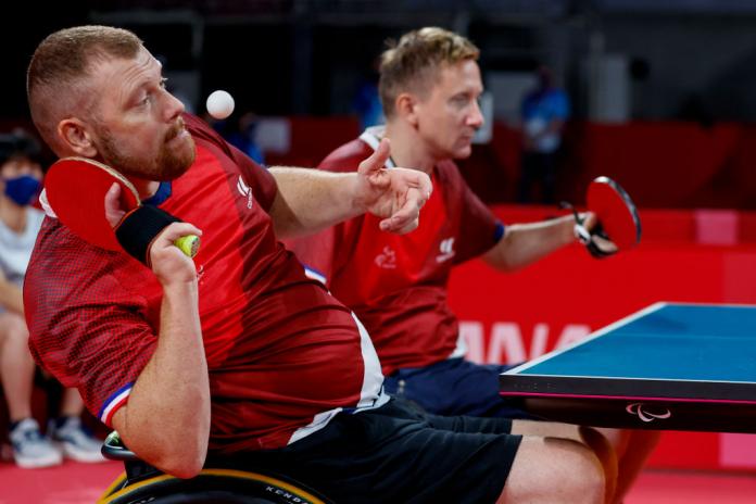 Two male Para table tennis athletes in action. 