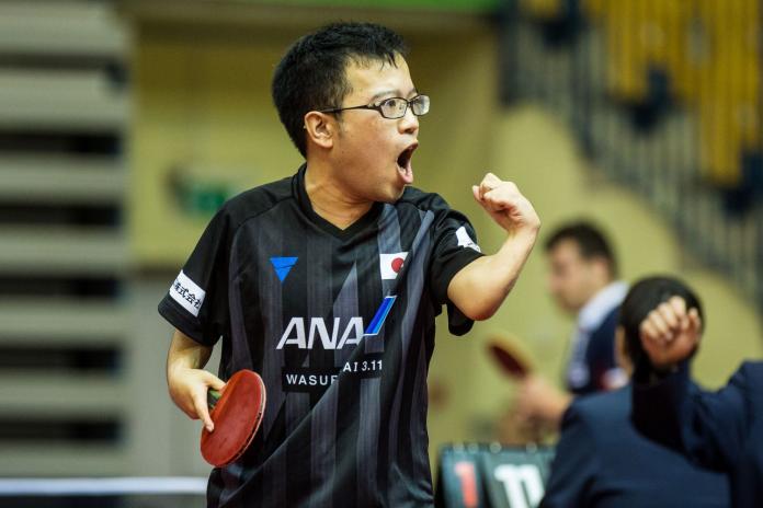 A male Para table tennis player pumps his left fist during a match