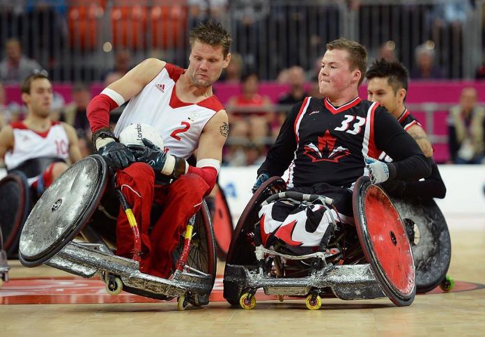 Two male wheelchair rugby players collide during a game at London 2012