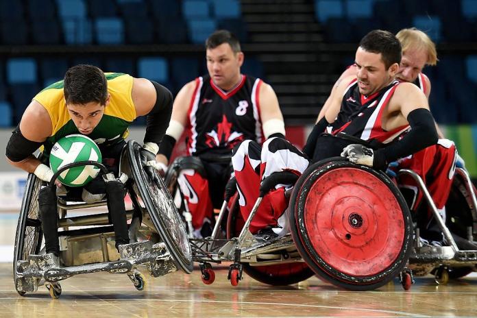 Four male wheelchair rugby players in action