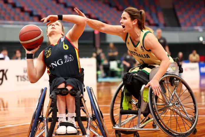 A female wheelchair basketball athlete tries to throw the ball