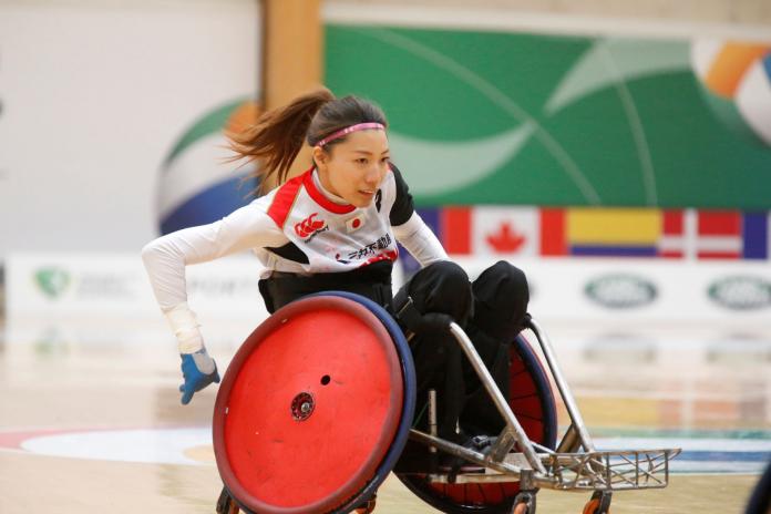 A female wheelchair rugby player maneuvers her wheelchair during a match 