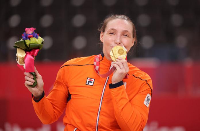 A female Para athlete kisses a gold medal