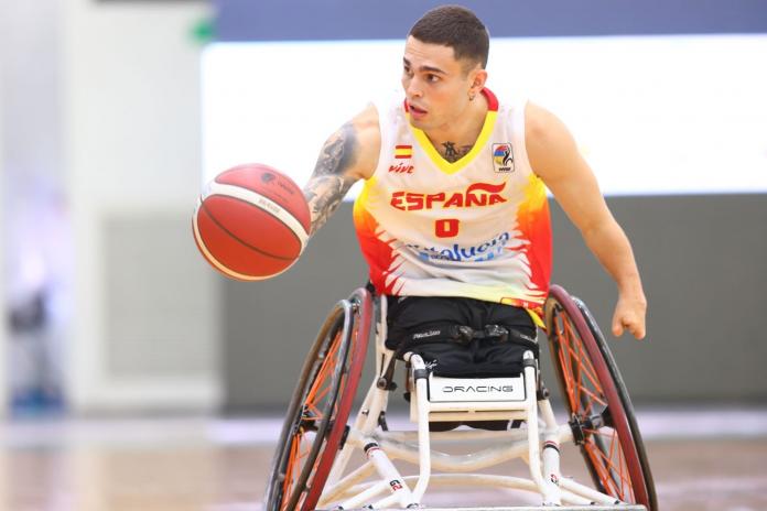 A male wheelchair basketball player controls the ball