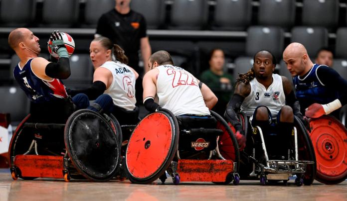 USA wheelchair rugby player Sarah Adam tries to block a male athlete from throwing the ball. 