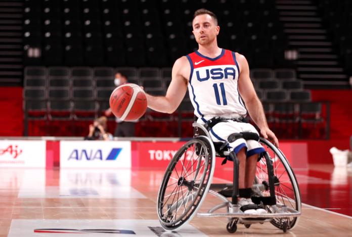 A male wheelchair basketball player carries the ball during a match